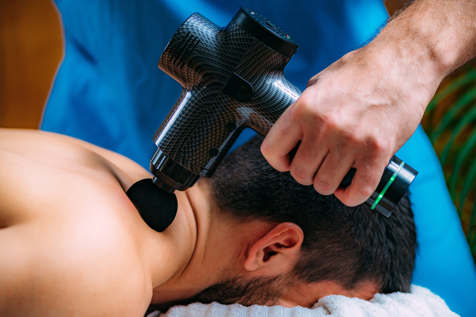 Therapist Treating Patient’s Trapezius Muscle with Massage Gun